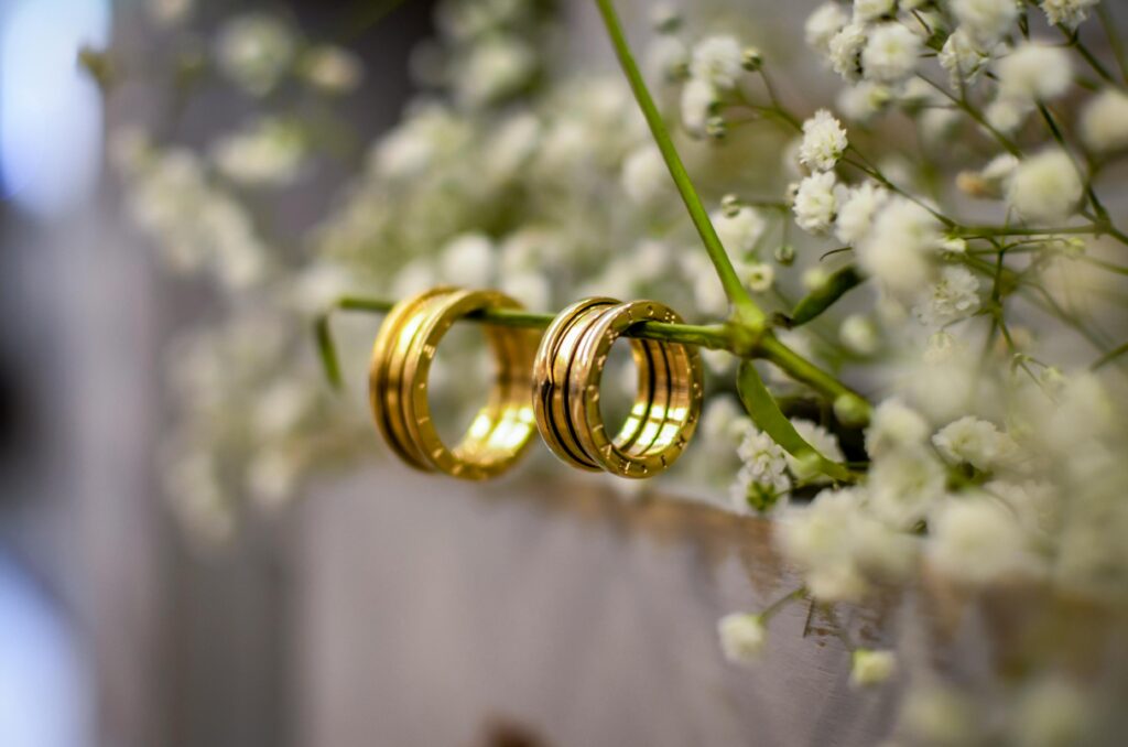 Close-up of shimmering gold wedding bands delicately resting on baby's breath flowers, symbolizing love and commitment.